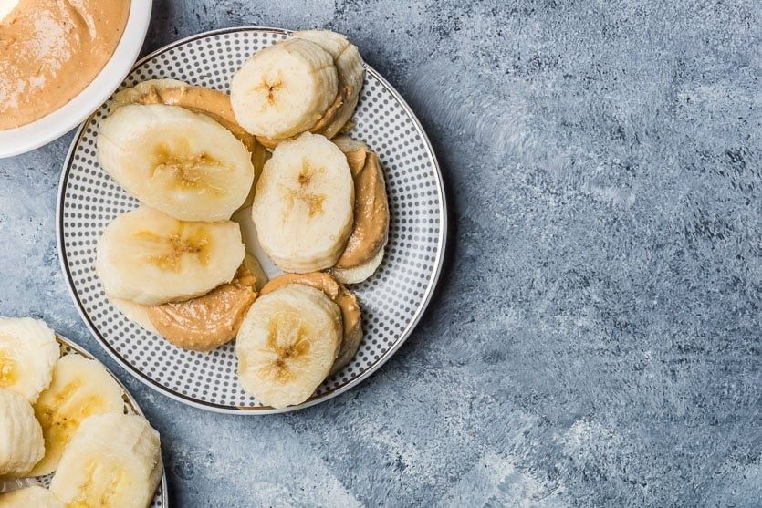Bananskivor med jordnötssmör på en prickig tallrik
